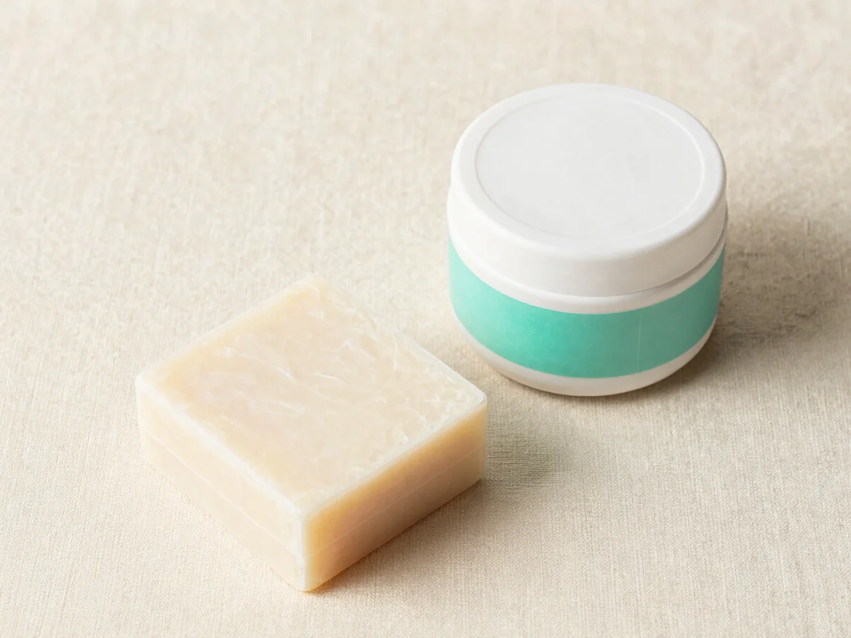 Overhead studio shot on white, a shampoo bar and a jar of conditi